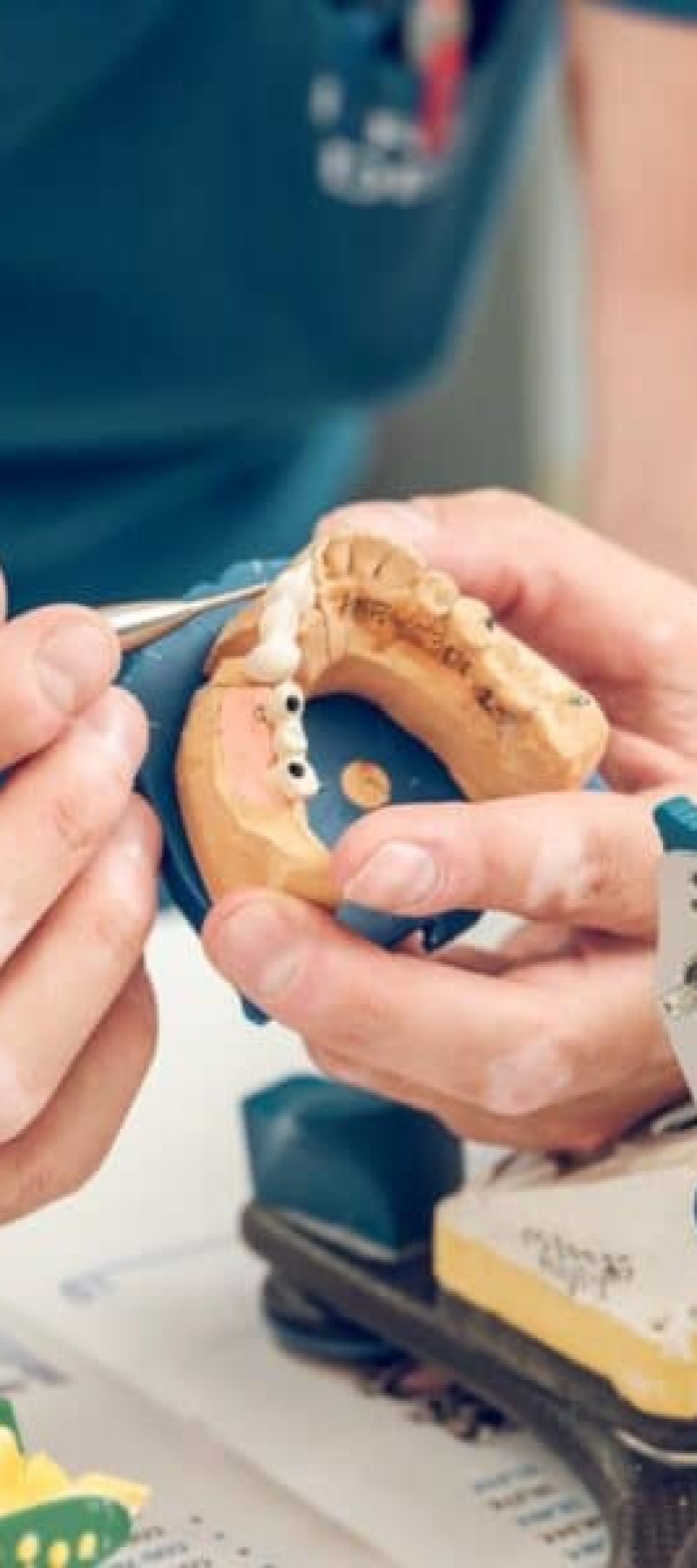 Crop man dental technician using tools making implant jaws