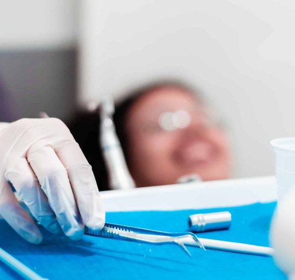 image of the hands of a professional dentist holding a dental cleaning instrument.